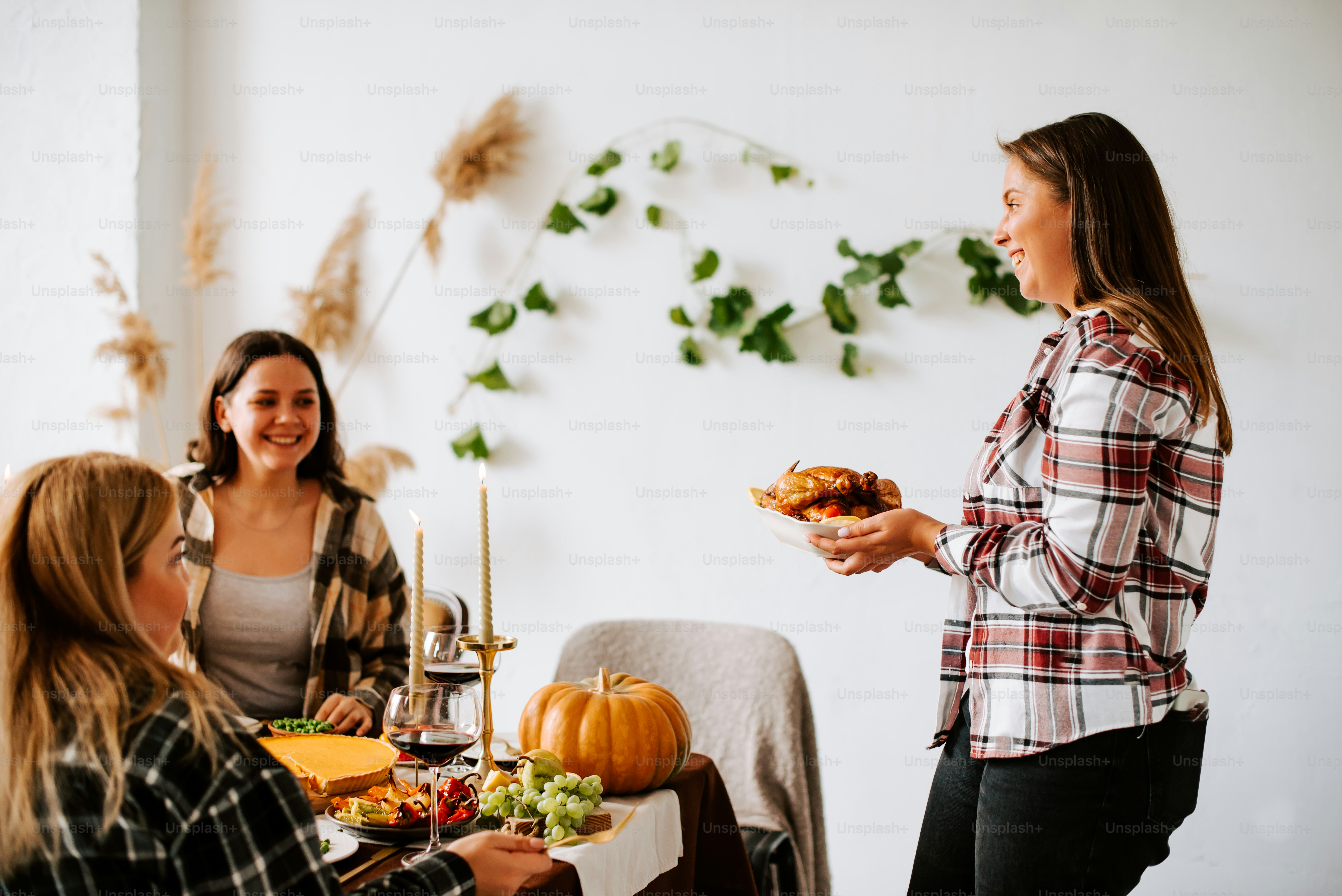 a group of women standing around a table with food