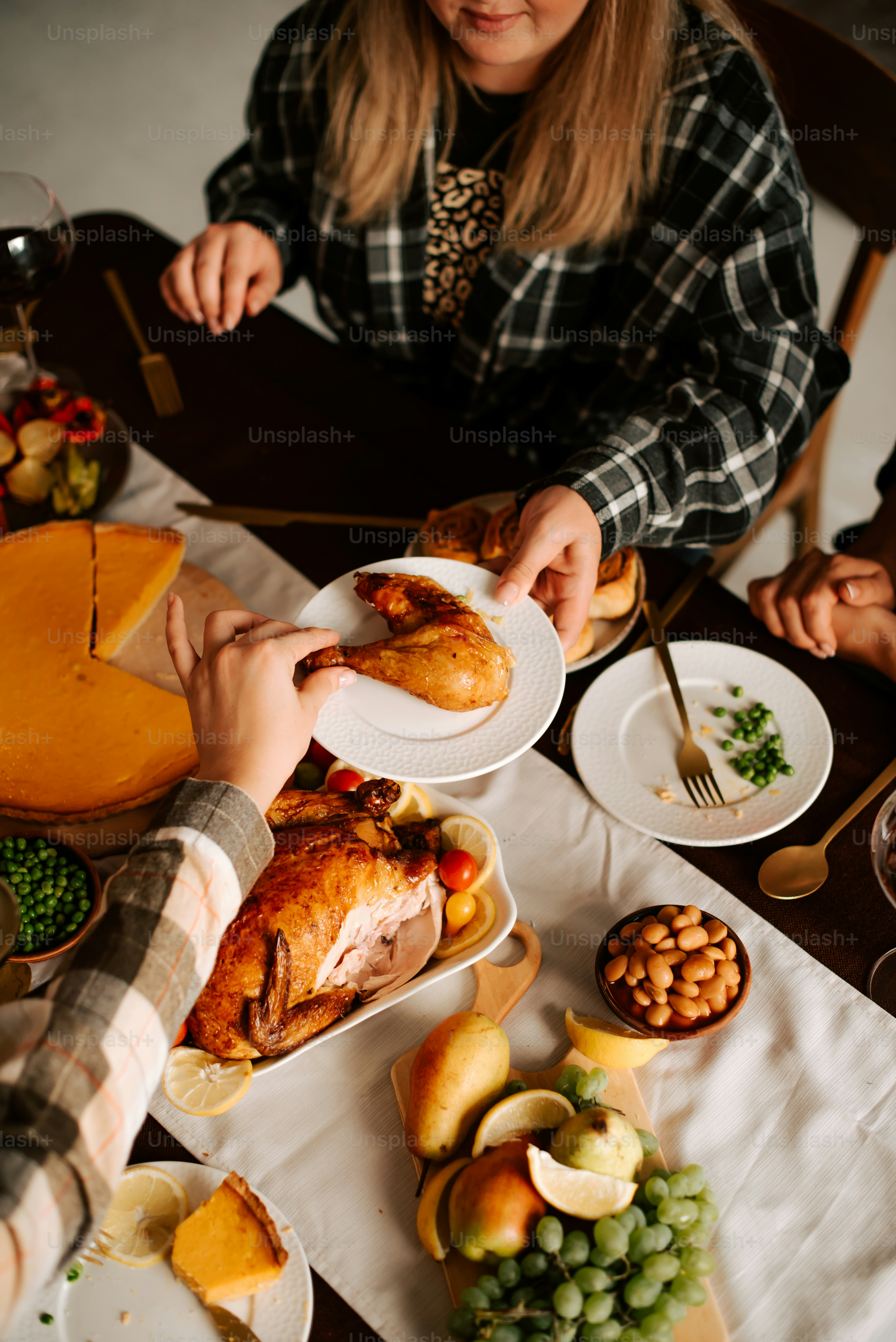a group of people sitting around a table with plates of food