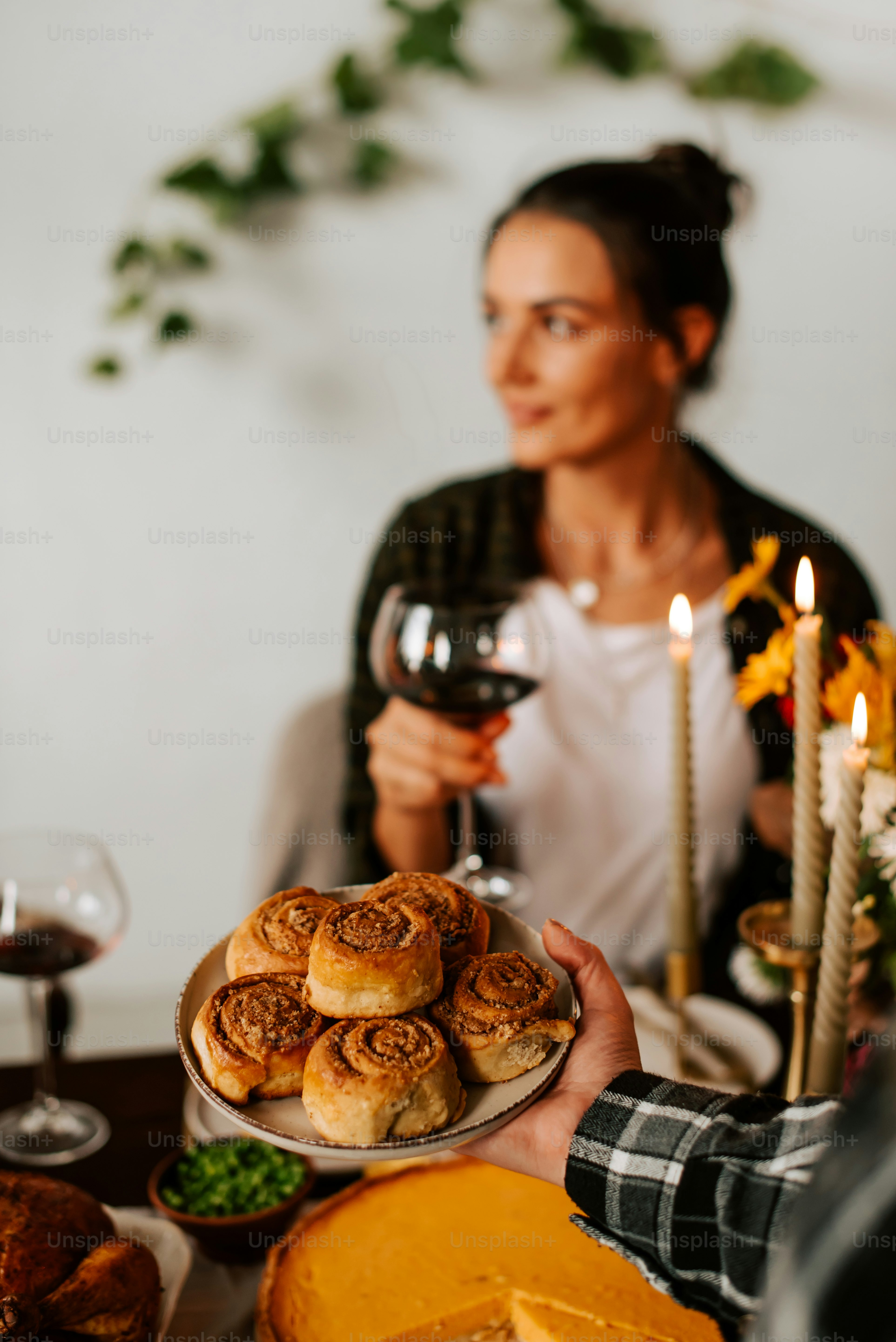 Une femme tenant une assiette de nourriture et un verre de vin