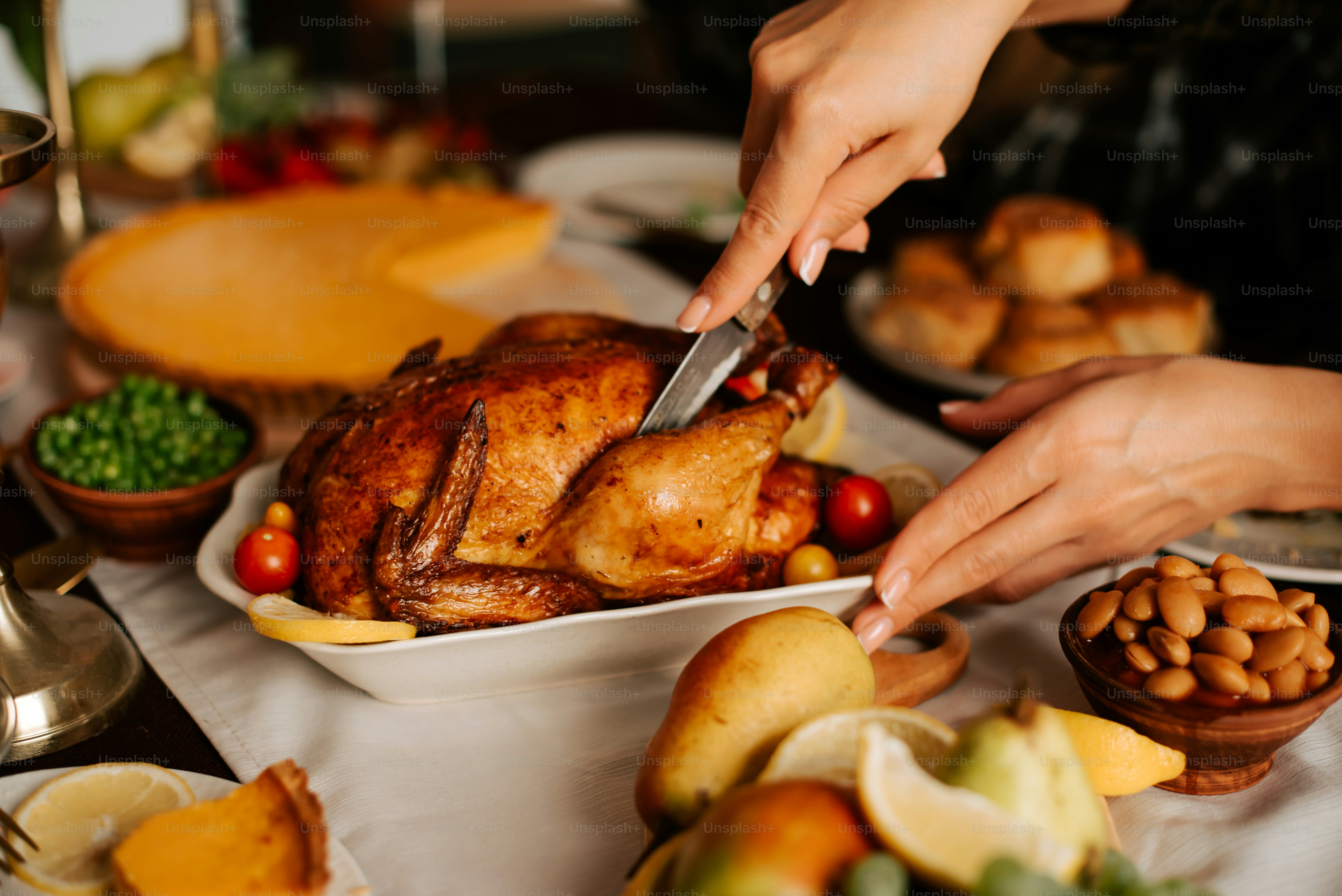 a person cutting a turkey on a table