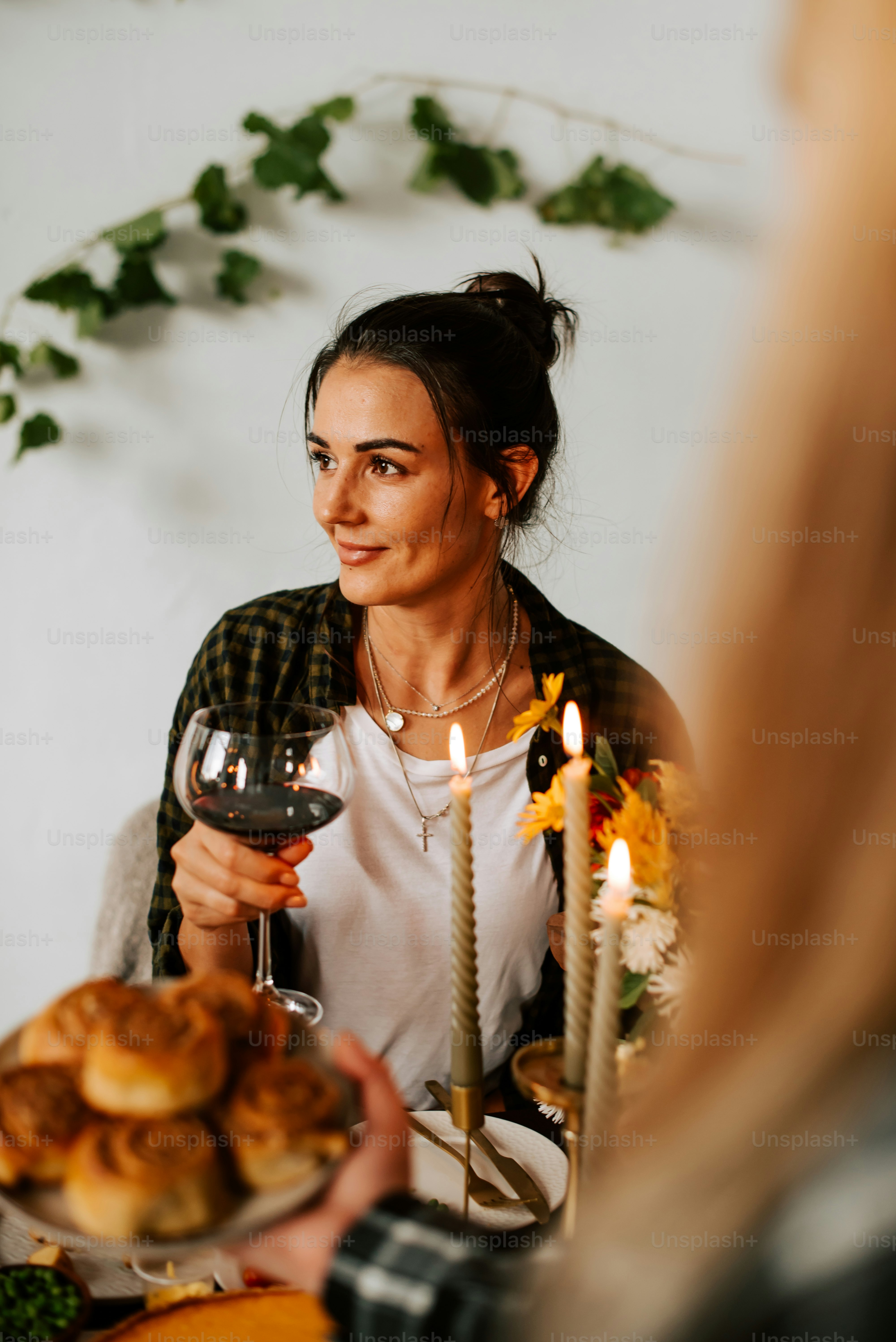 a woman sitting at a table holding a glass of wine