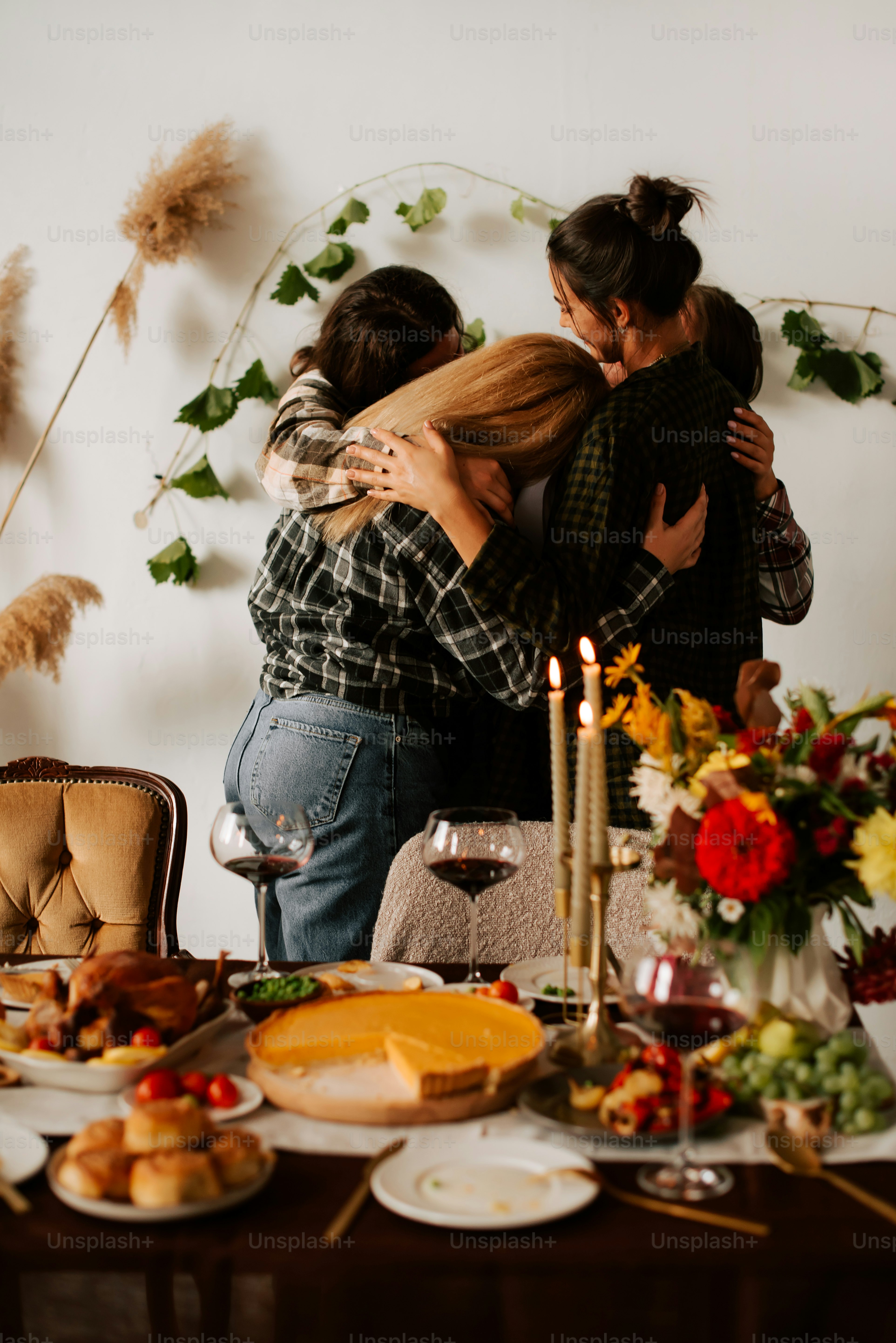 two women hugging each other at a dinner table