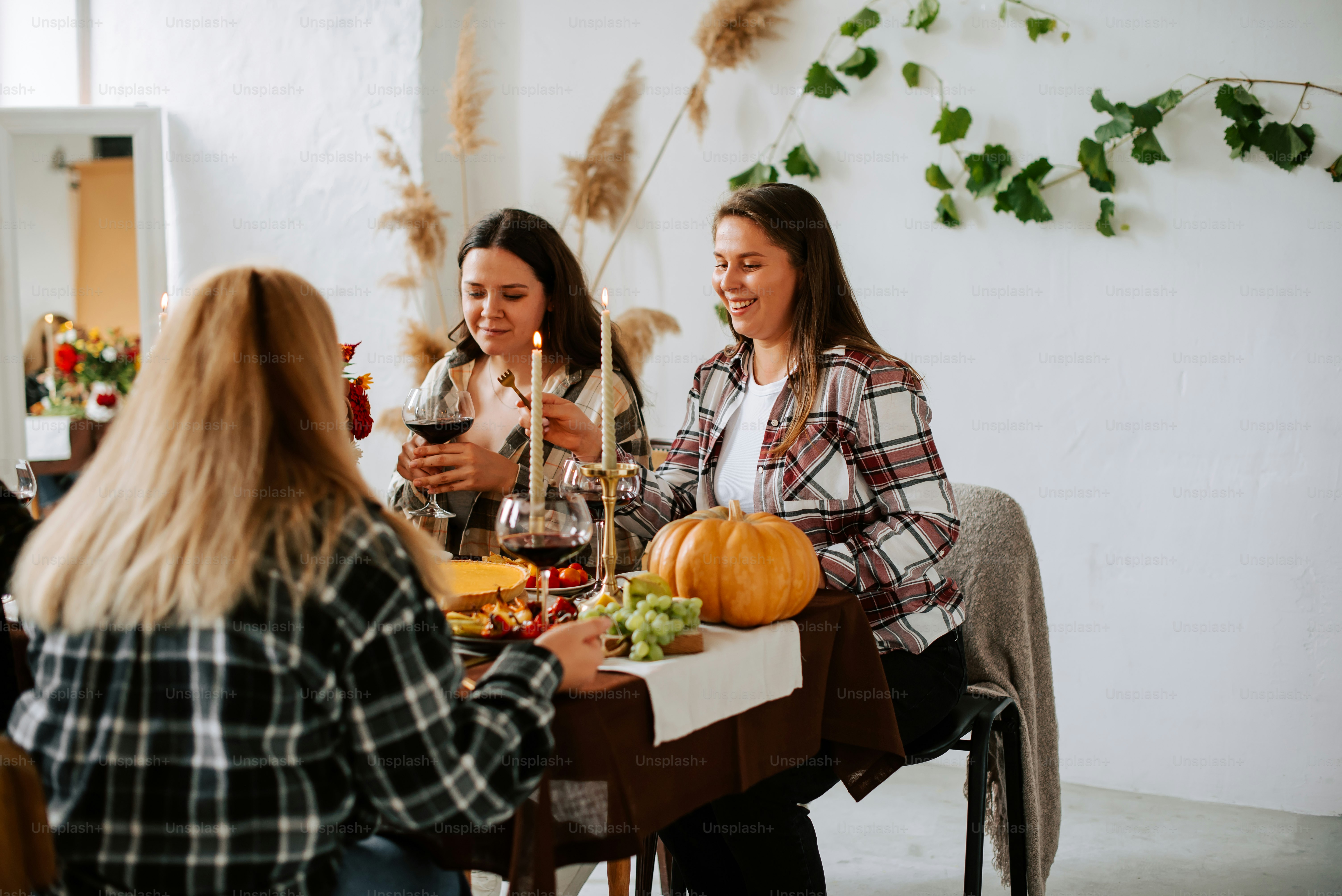 a group of women sitting around a table with food