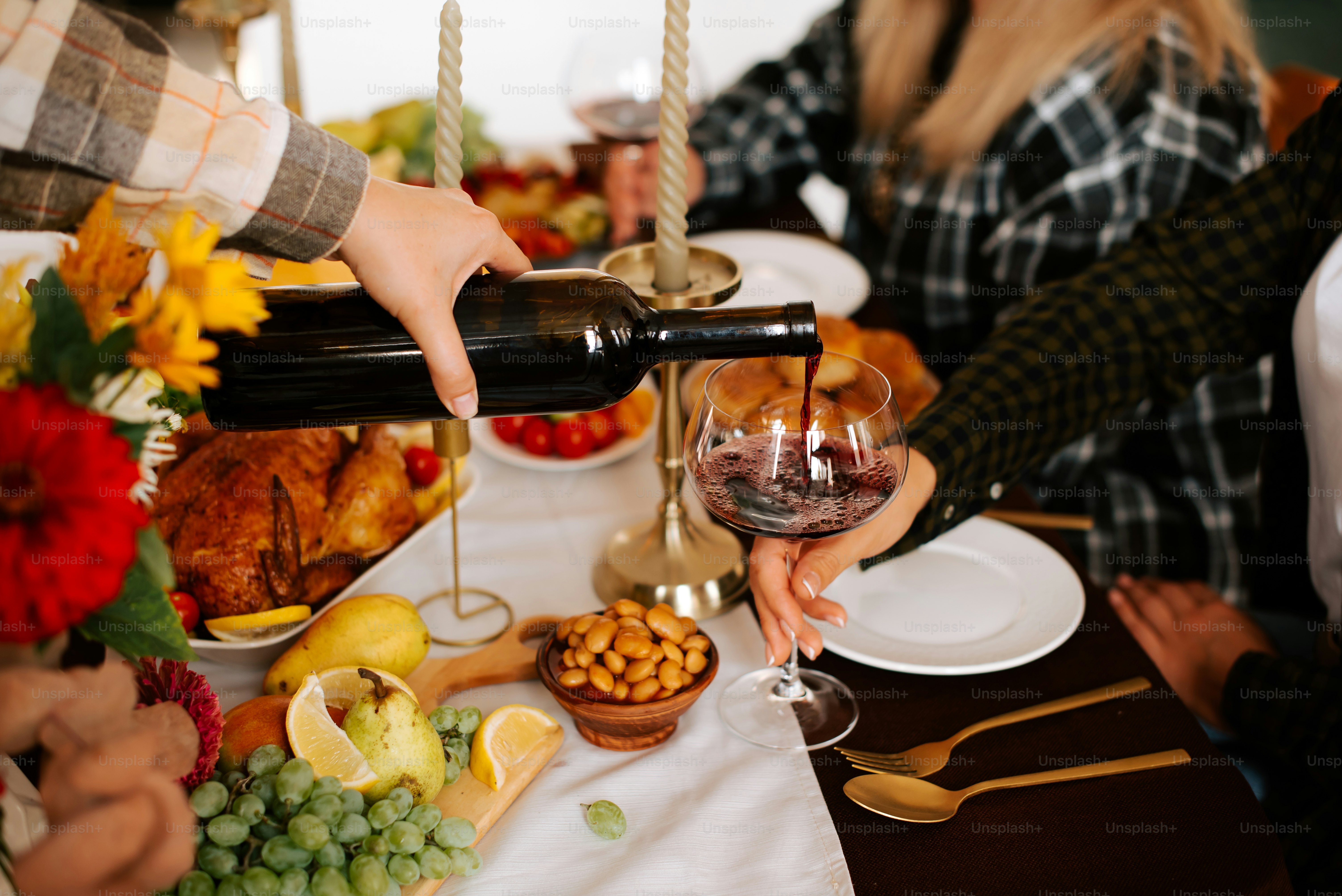 a person pouring a glass of wine at a table