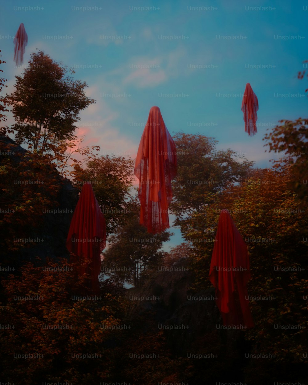 a group of red umbrellas floating in the air