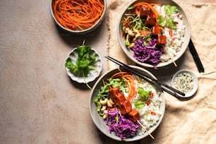 two bowls of food with chopsticks on a table