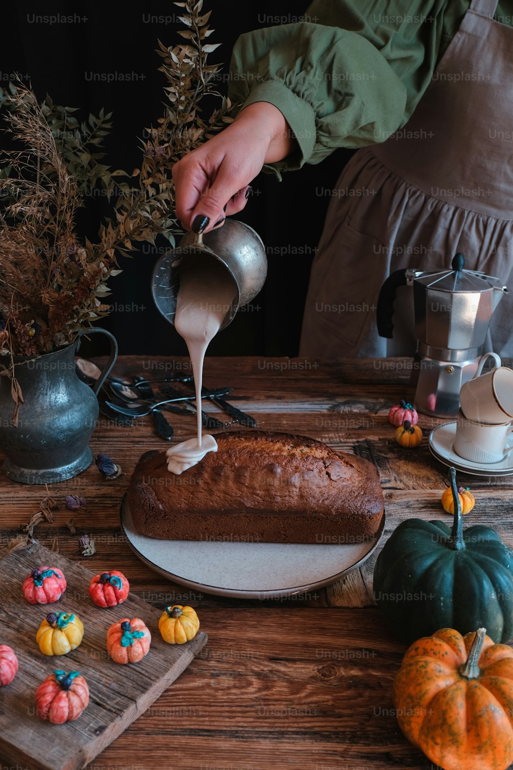 a person pouring sugar on a cake on a table