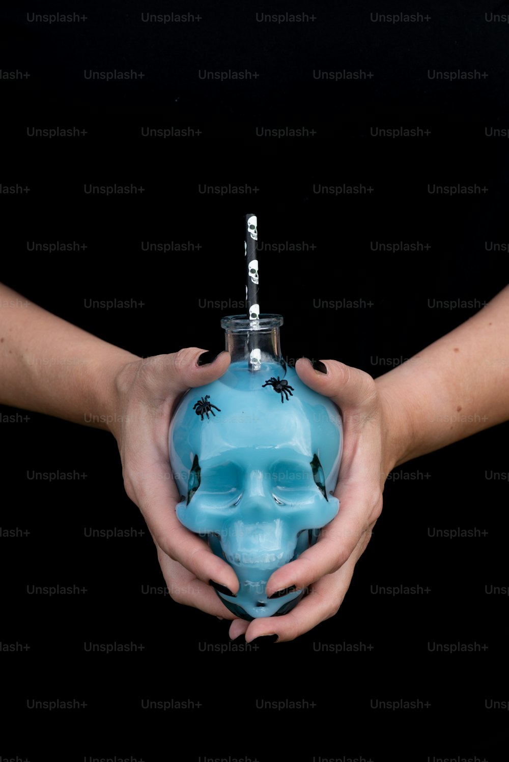 a person holding a blue vase with a skull on it