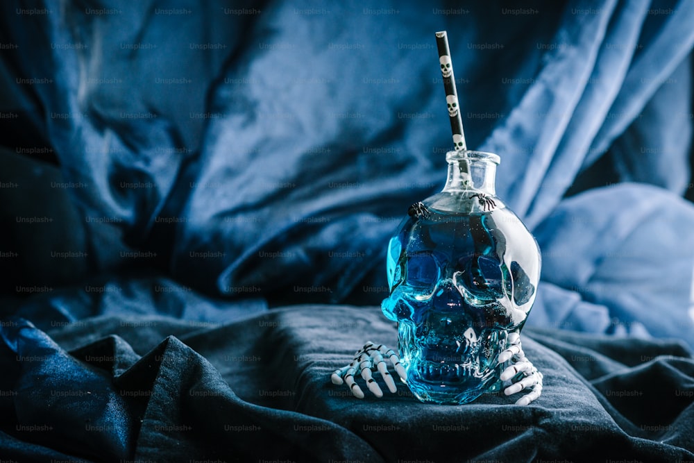 a skull shaped glass bottle with a toothbrush in it