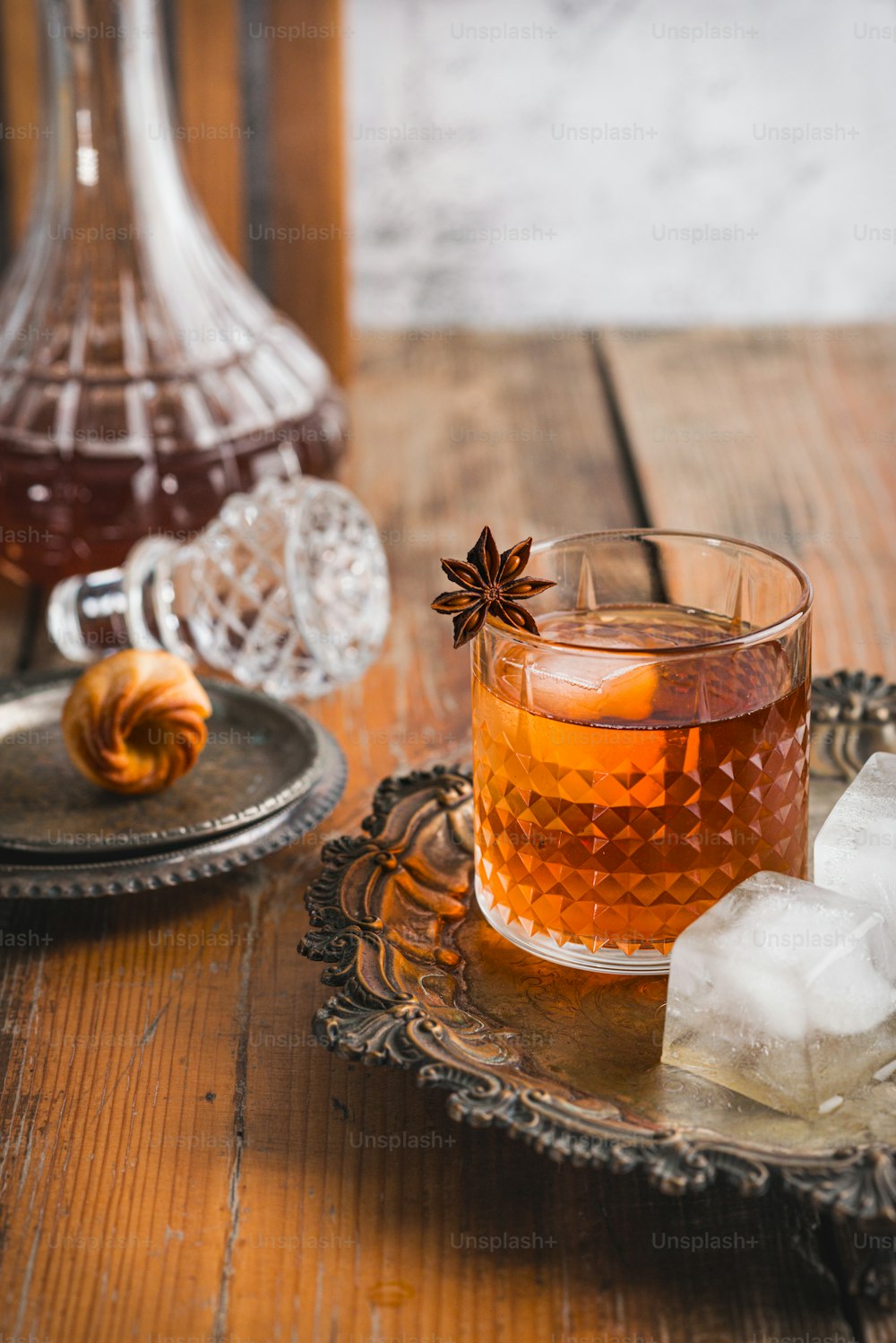 un bicchiere di tè con anice e ghiaccio su un vassoio