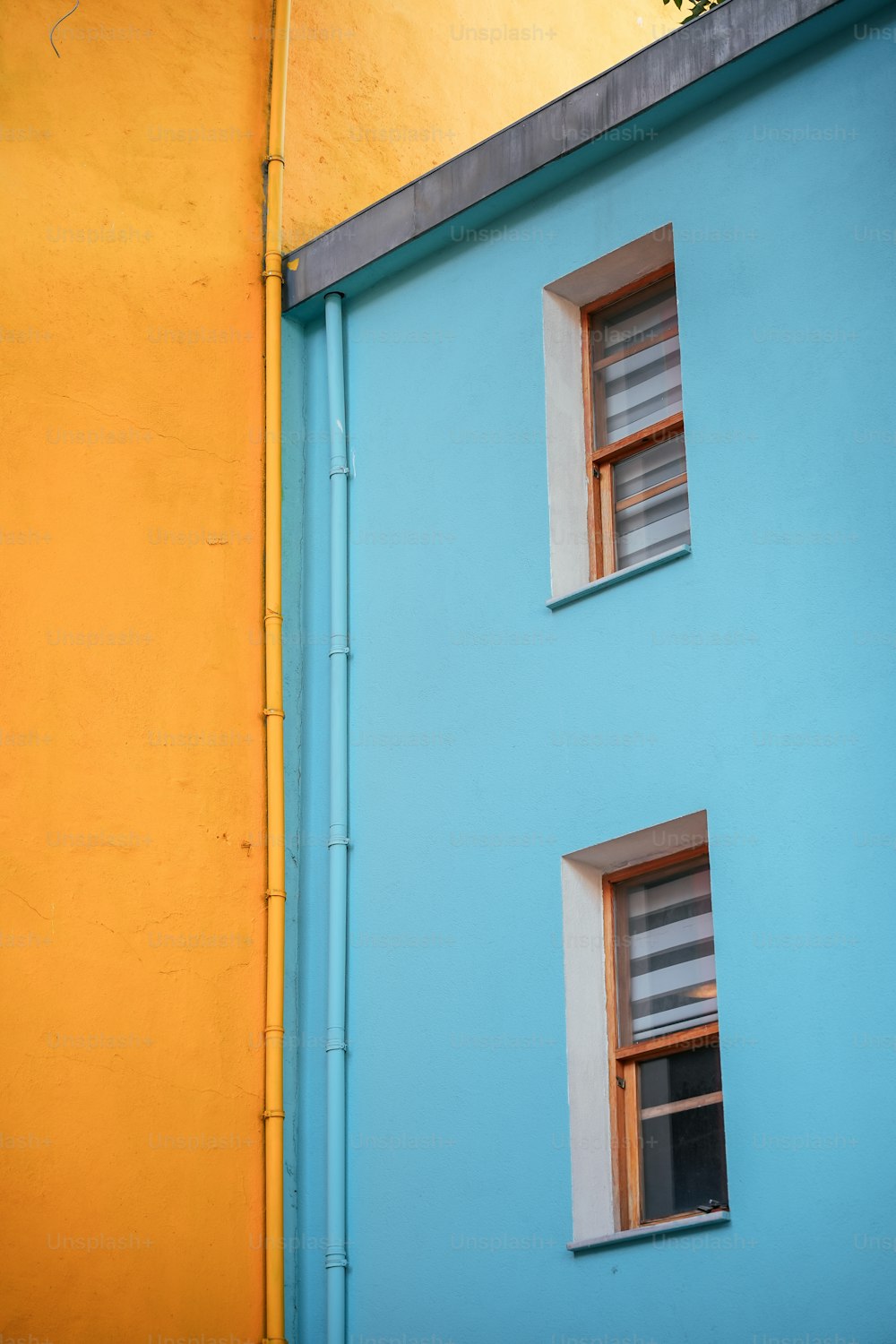 a blue and yellow building with two windows