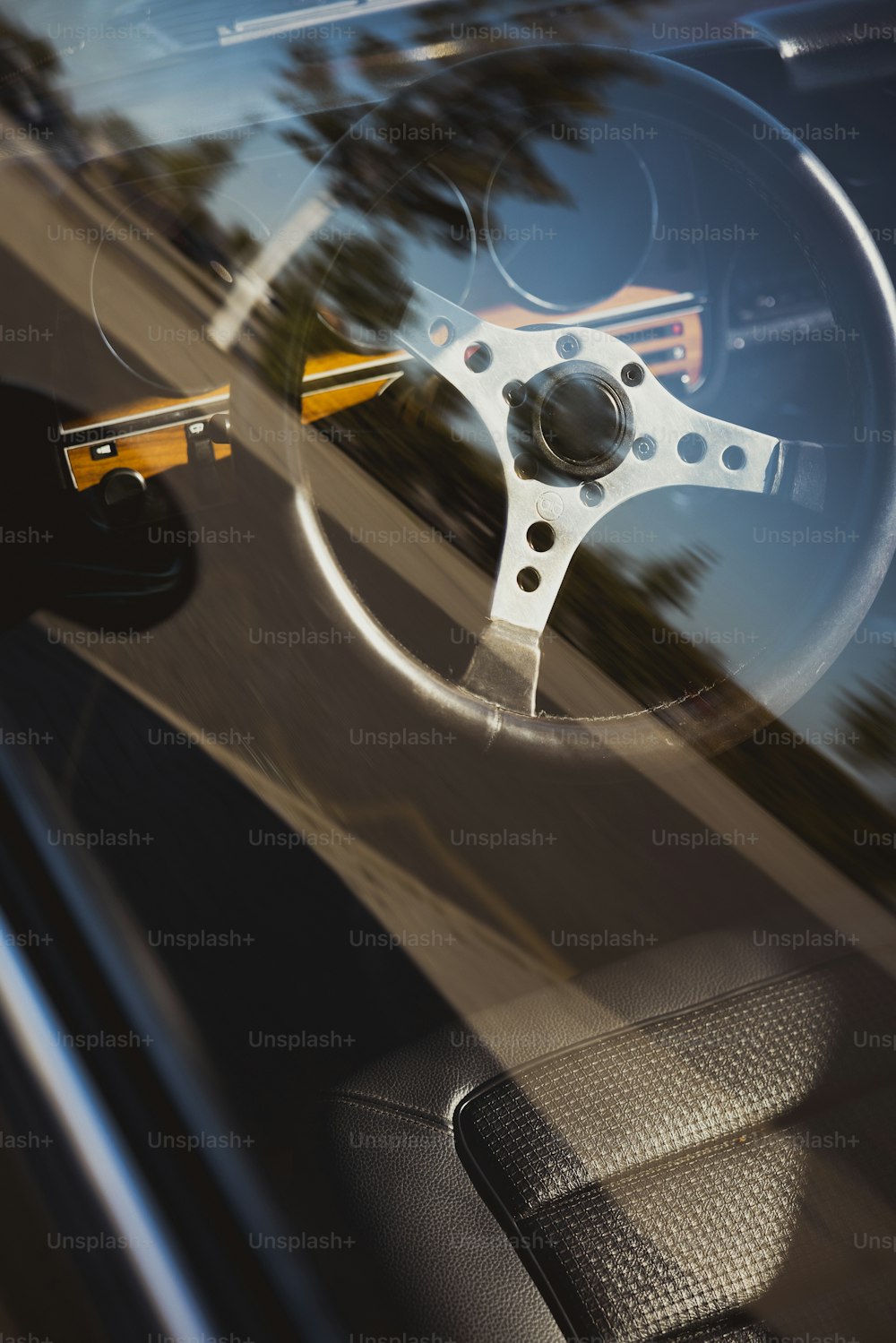 the steering wheel of a car is seen through the windshield