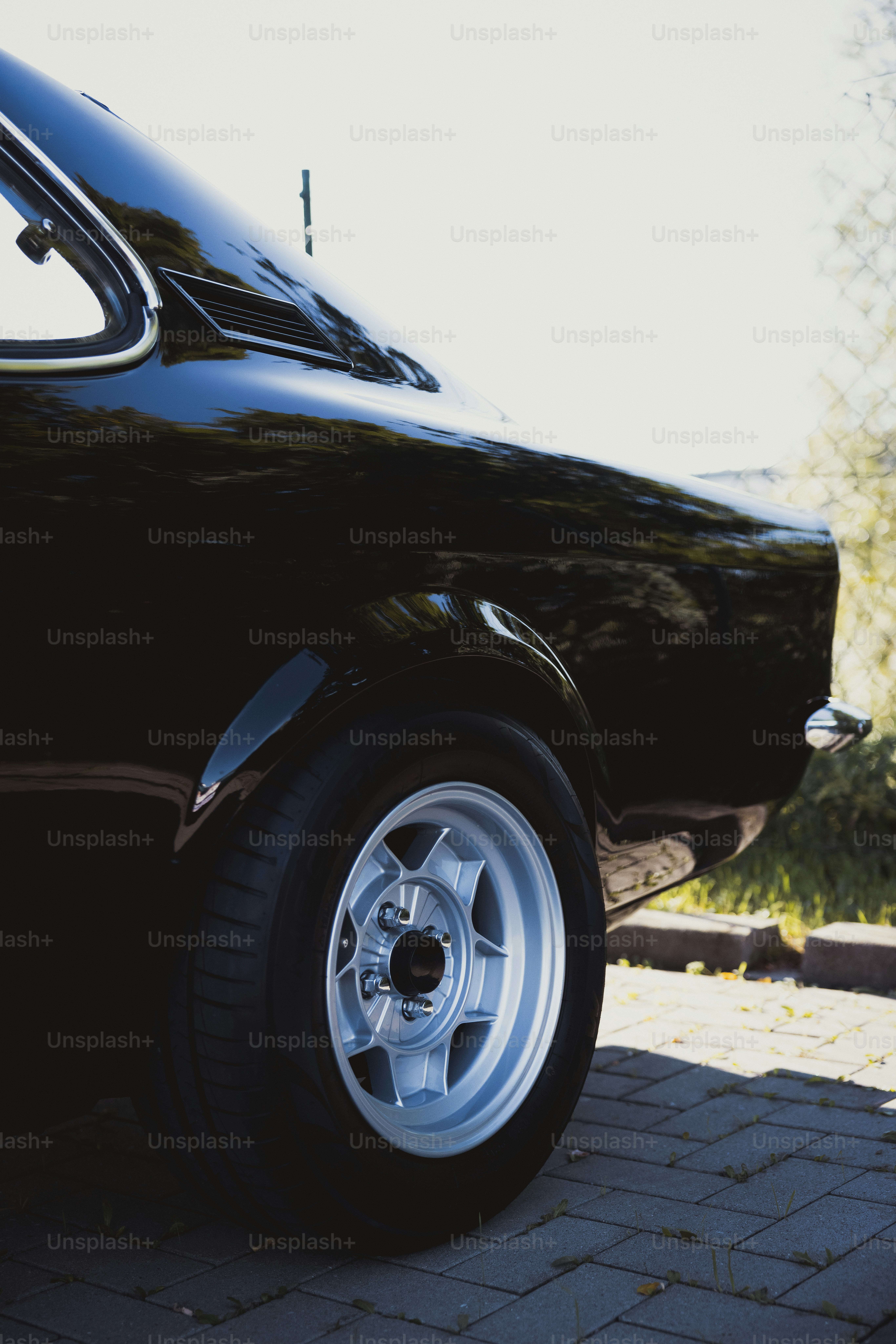 a black car parked on a brick road