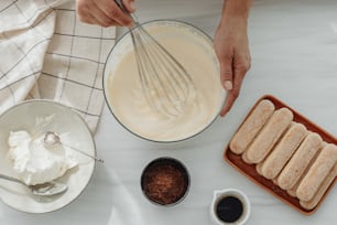 a person mixing batter in a bowl with a whisk