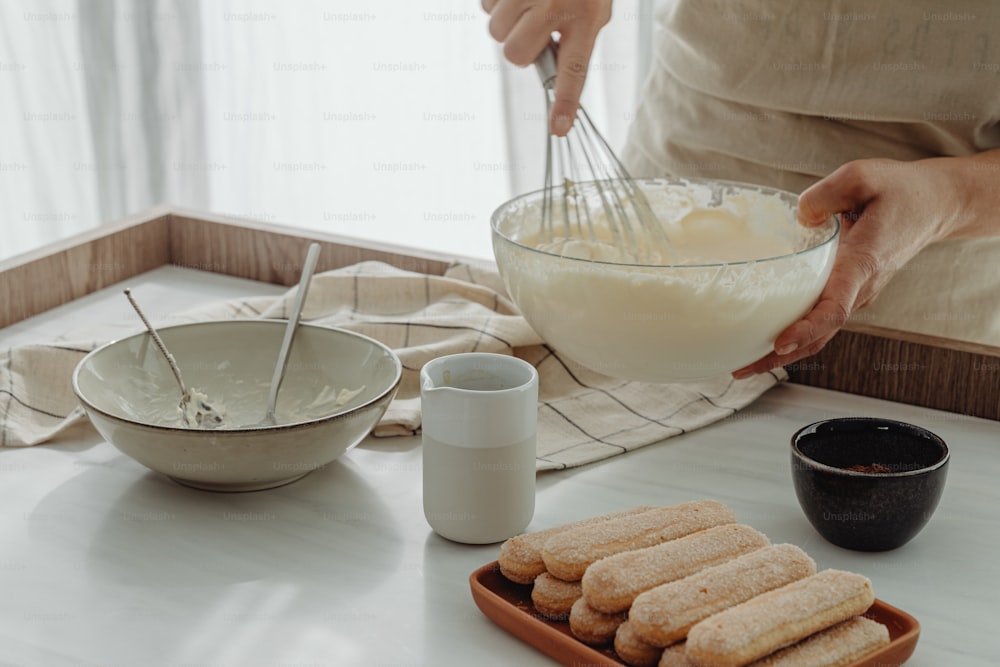 a person whisking cookies in a bowl with a whisk