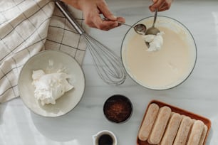 a person mixing ingredients in a bowl on a table