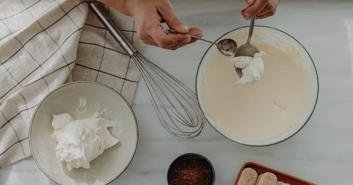 Mixing Ingredients Example A person mixing ingredients in a bowl on a table photo – Dessert Image ...