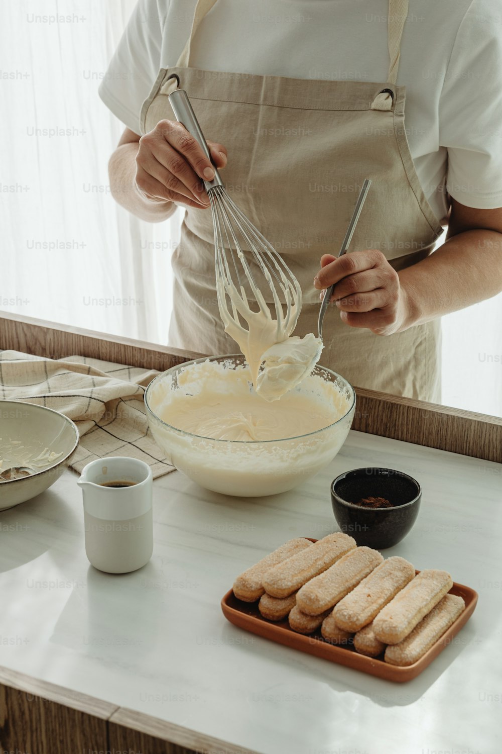 a person with a whisk in a bowl on a counter