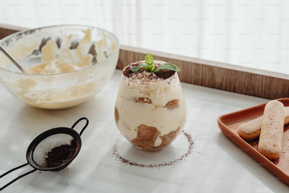 a dessert is sitting on a table next to a bowl of cookies