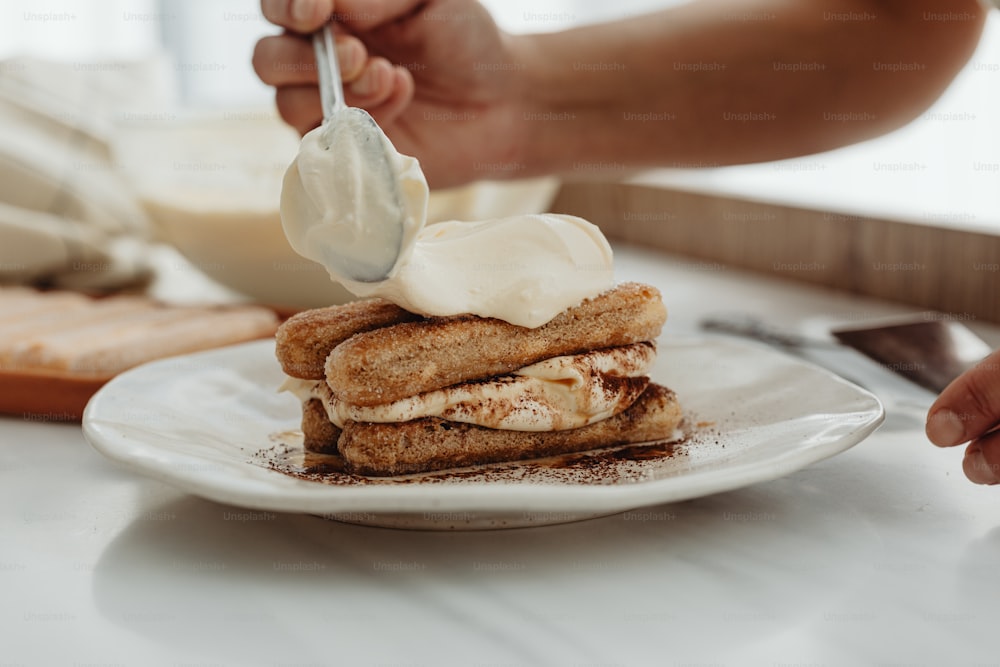 a person is spreading cream on a dessert