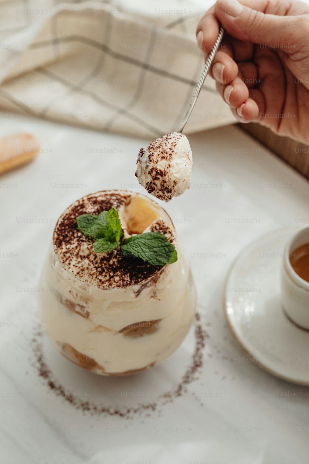 a person holding a spoon with a dessert on it