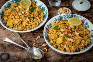 two bowls of rice with nuts and lemon on a table