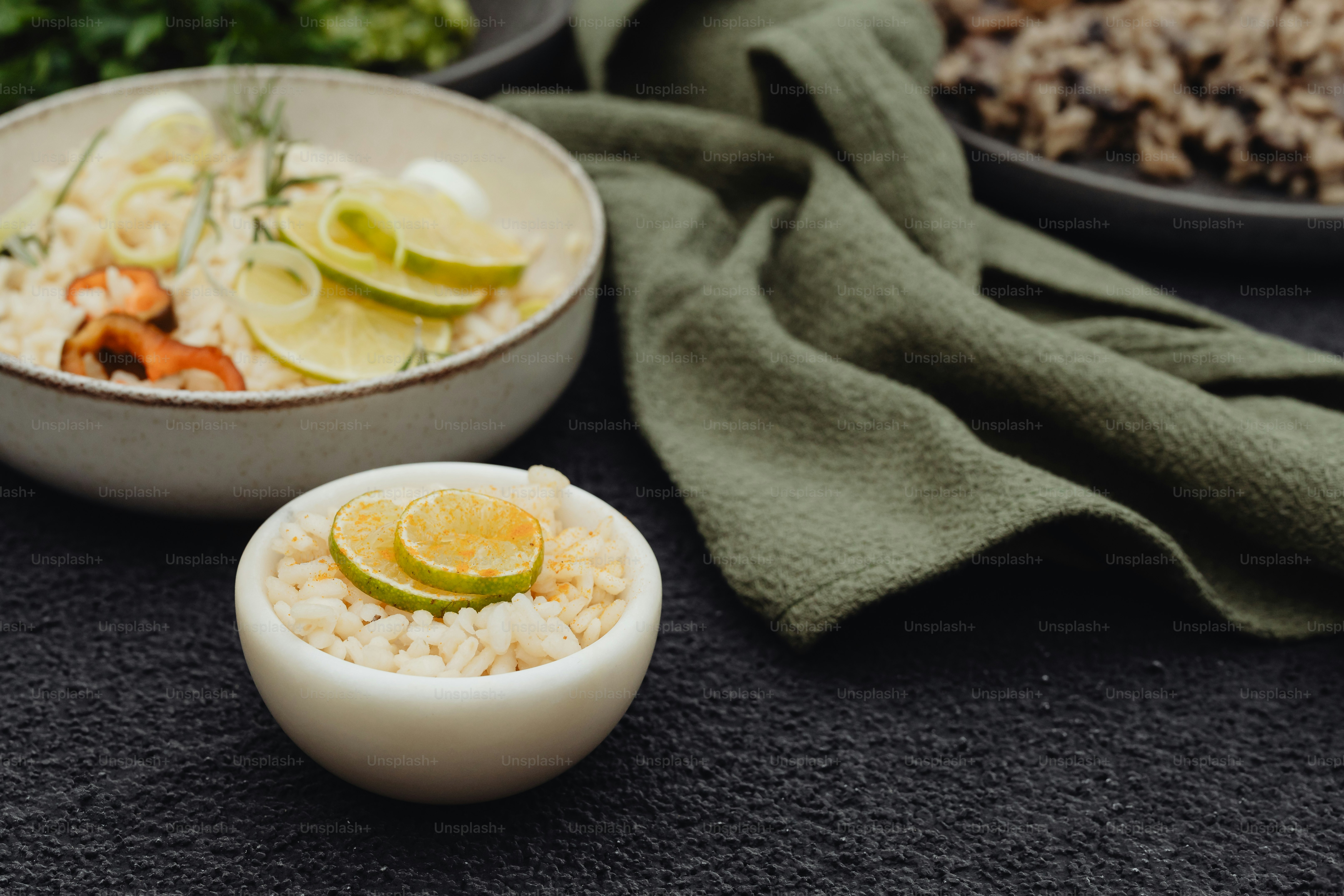A bowl of rice and a bowl of vegetables on a table photo – Food Image ...