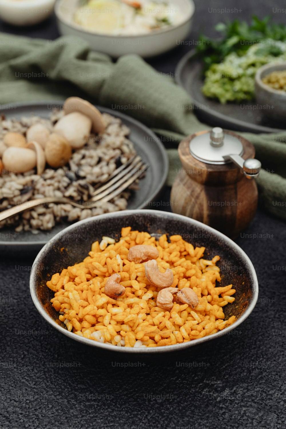 a table topped with plates of food and a bowl of rice