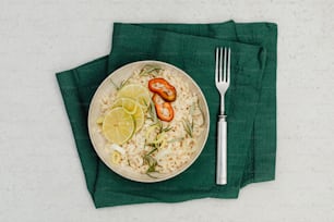 a white plate topped with rice and vegetables next to a fork