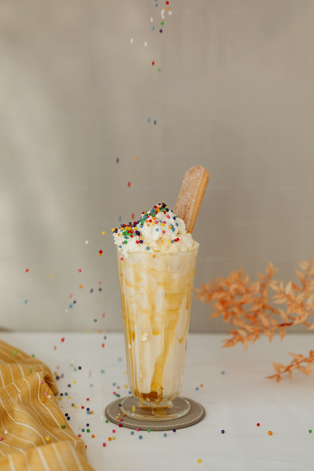 a tall glass filled with ice cream and sprinkles