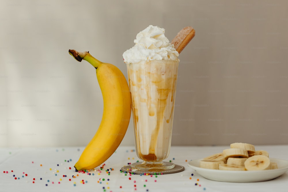 a banana sitting next to a glass of ice cream