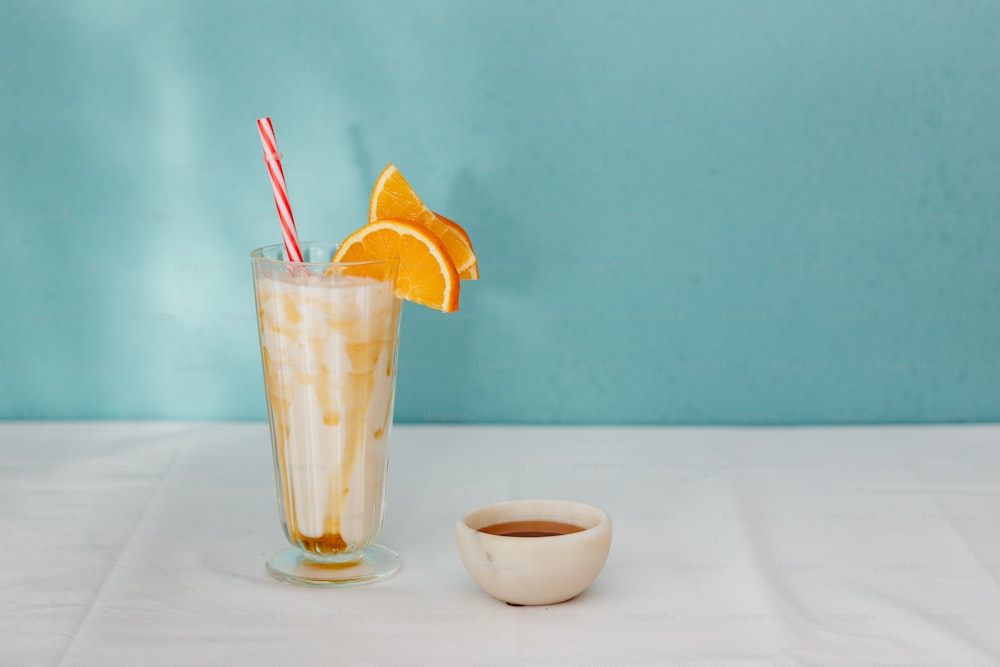ein Glas Eiskaffee mit Orangenscheiben und einem Strohhalm