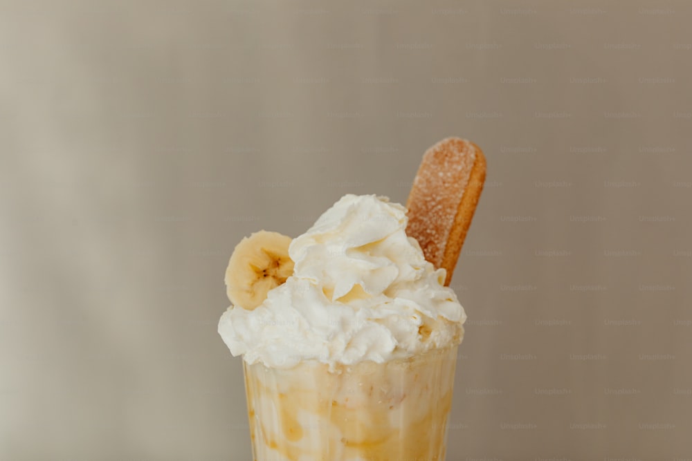 a banana and whipped cream drink with a cookie on top