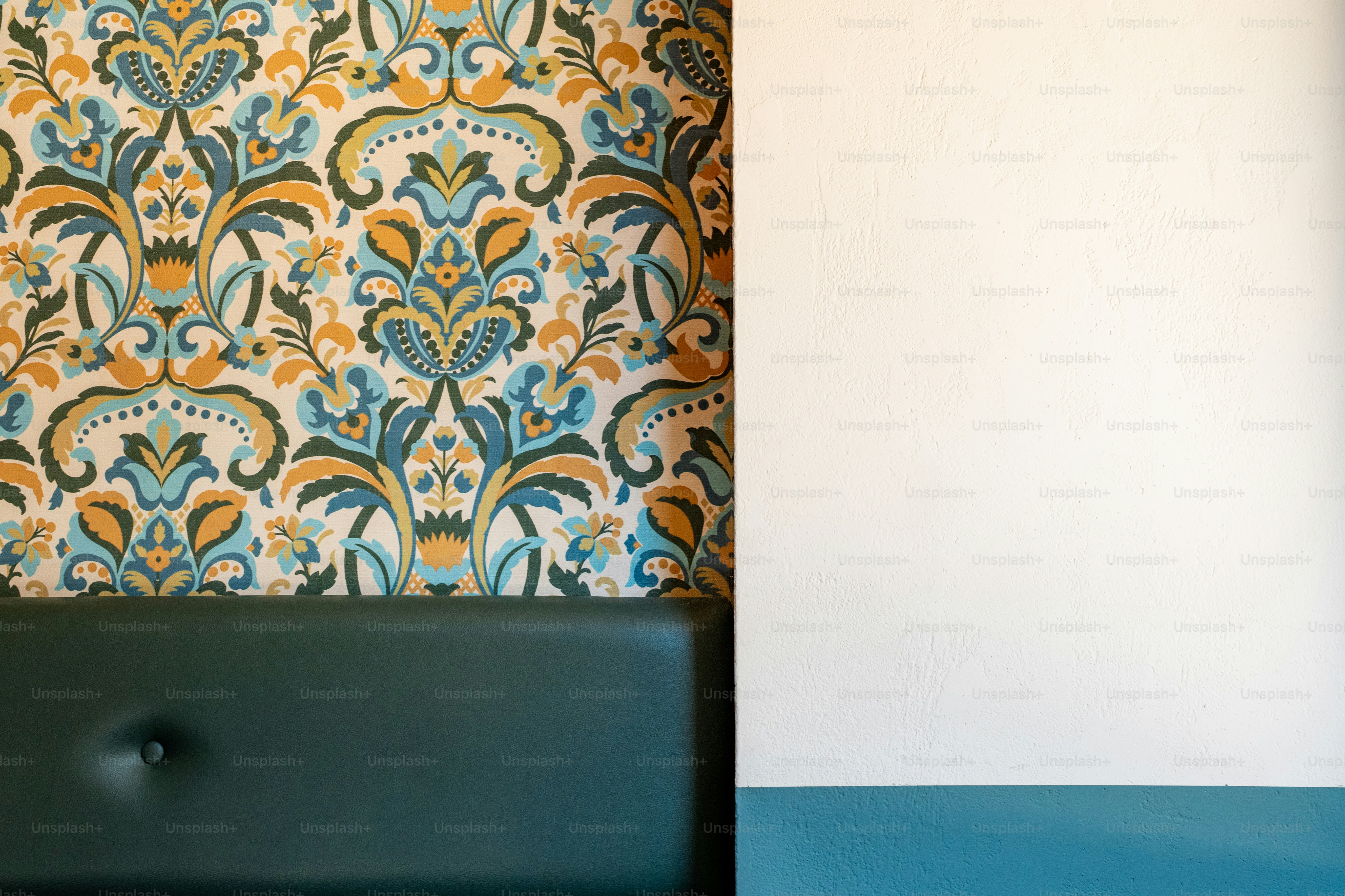 un mur avec un papier peint bleu et jaune et une chaise verte