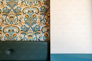 un mur avec un papier peint bleu et jaune et une chaise verte