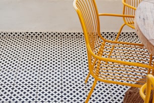 two yellow chairs sitting next to each other on a tiled floor