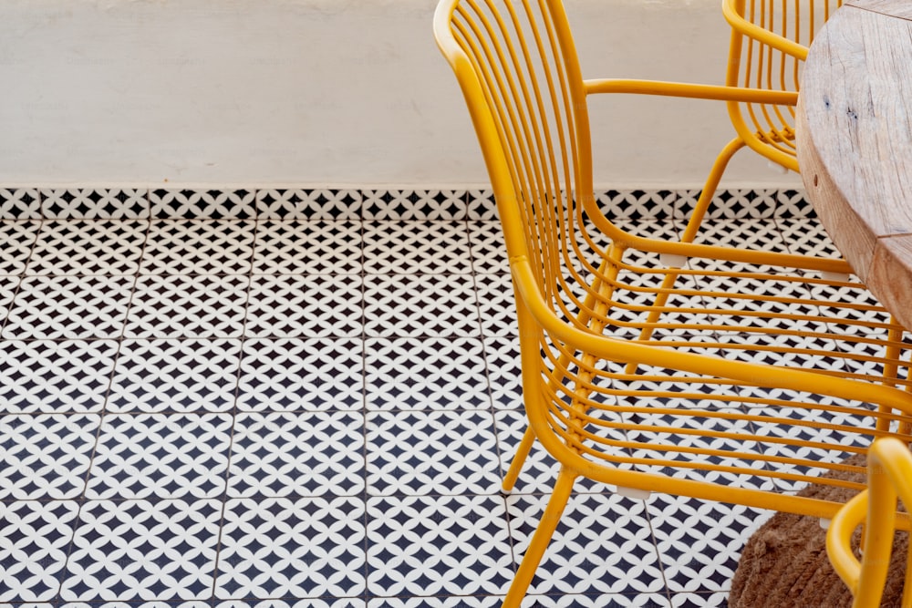 duas cadeiras amarelas sentadas uma ao lado da outra em um piso de azulejo