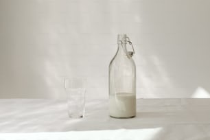 uma garrafa de leite ao lado de um copo de leite