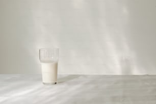 un bicchiere di latte seduto sopra un tavolo