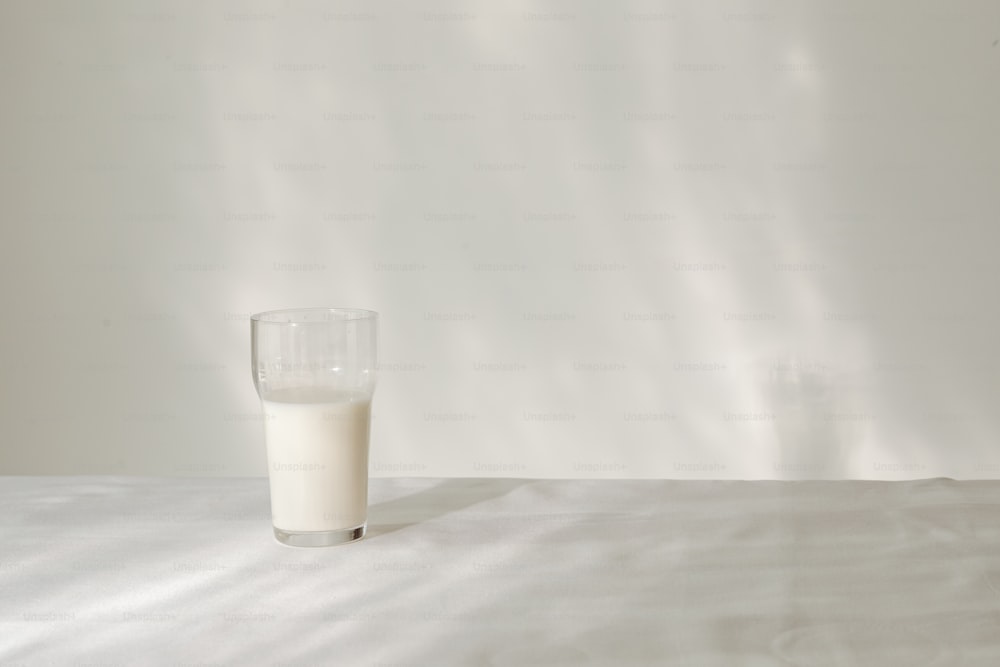 a glass of milk sitting on top of a table