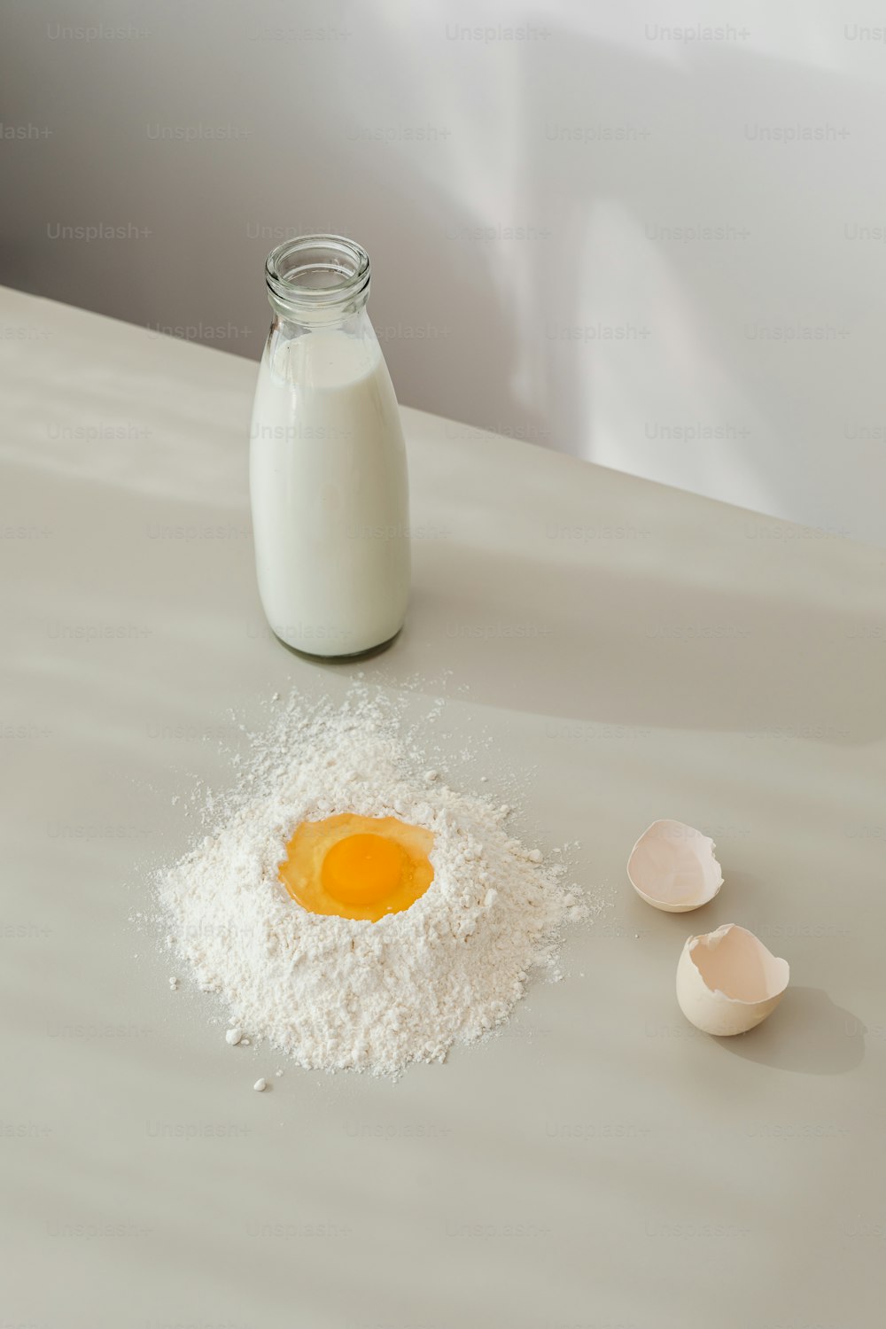 una botella de leche y dos huevos sobre una mesa