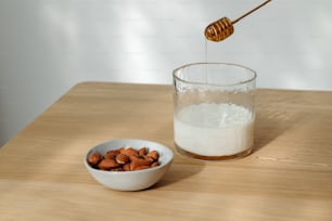a bowl of almonds and a glass of milk