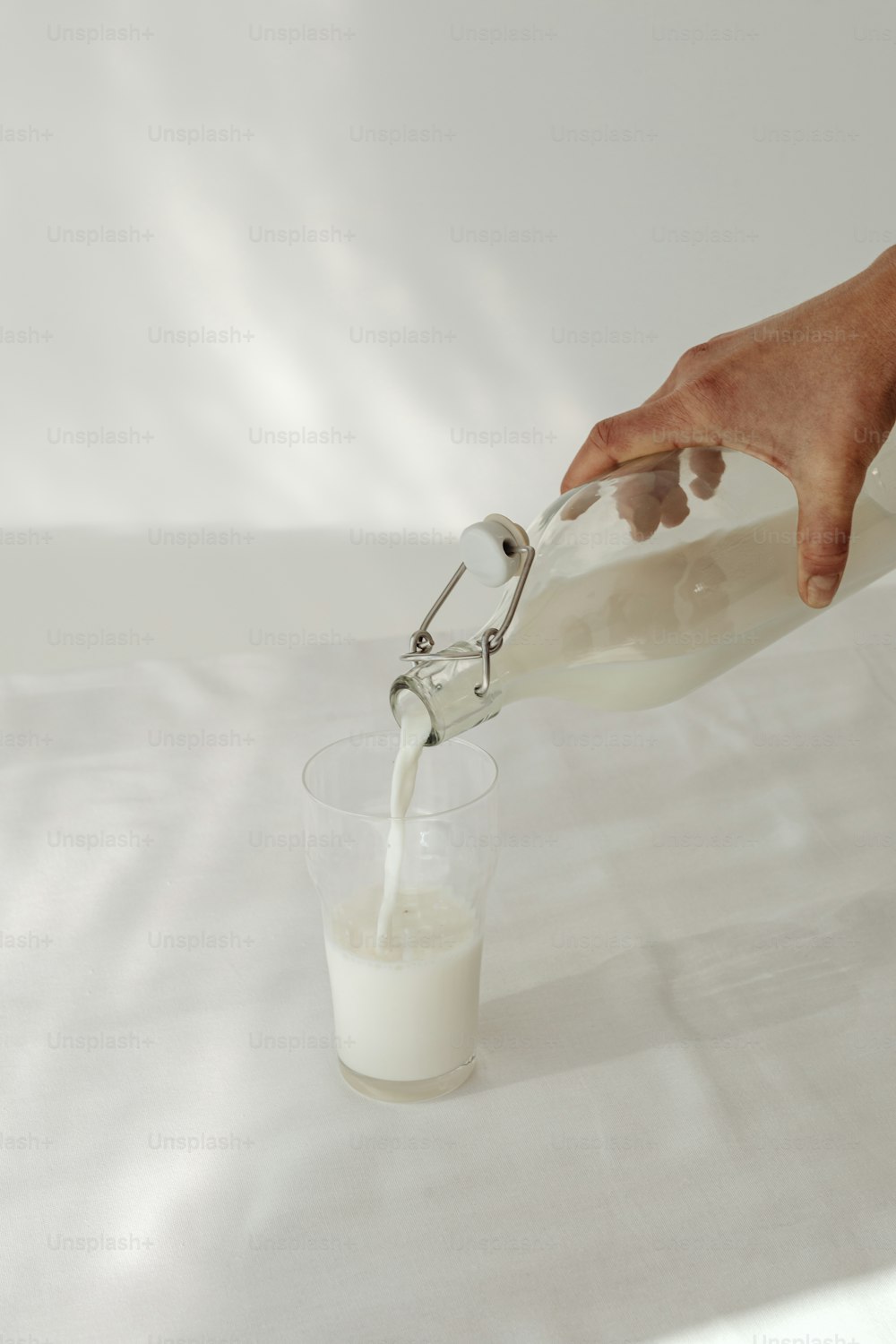 a person is pouring milk into a glass