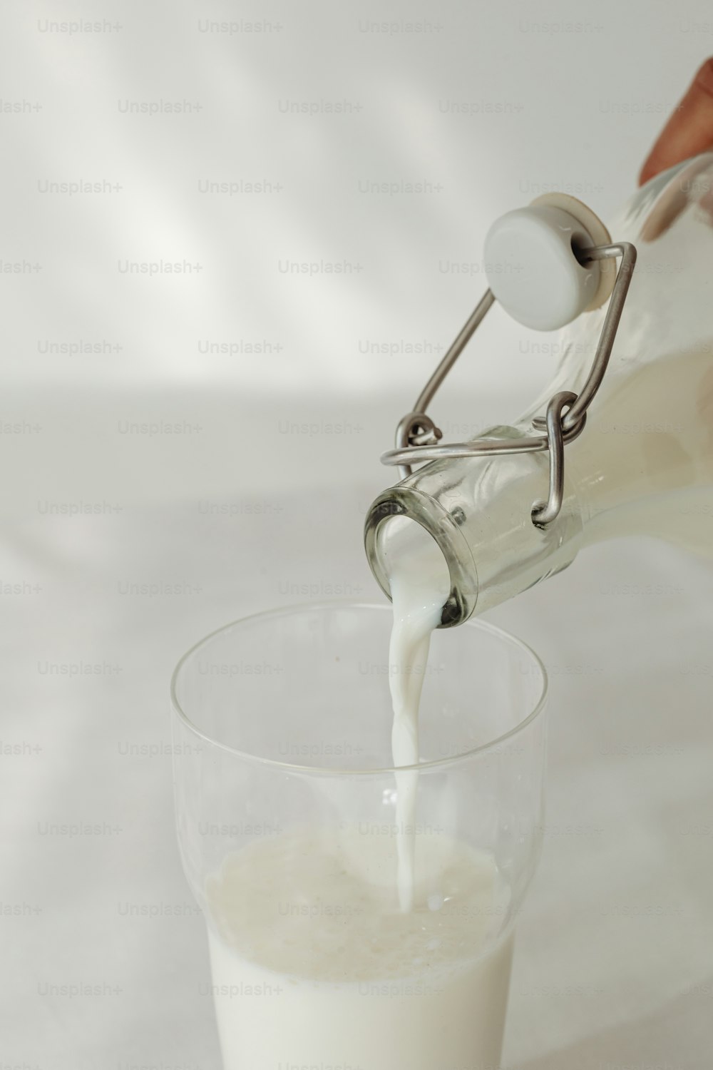 une personne versant du lait dans un verre