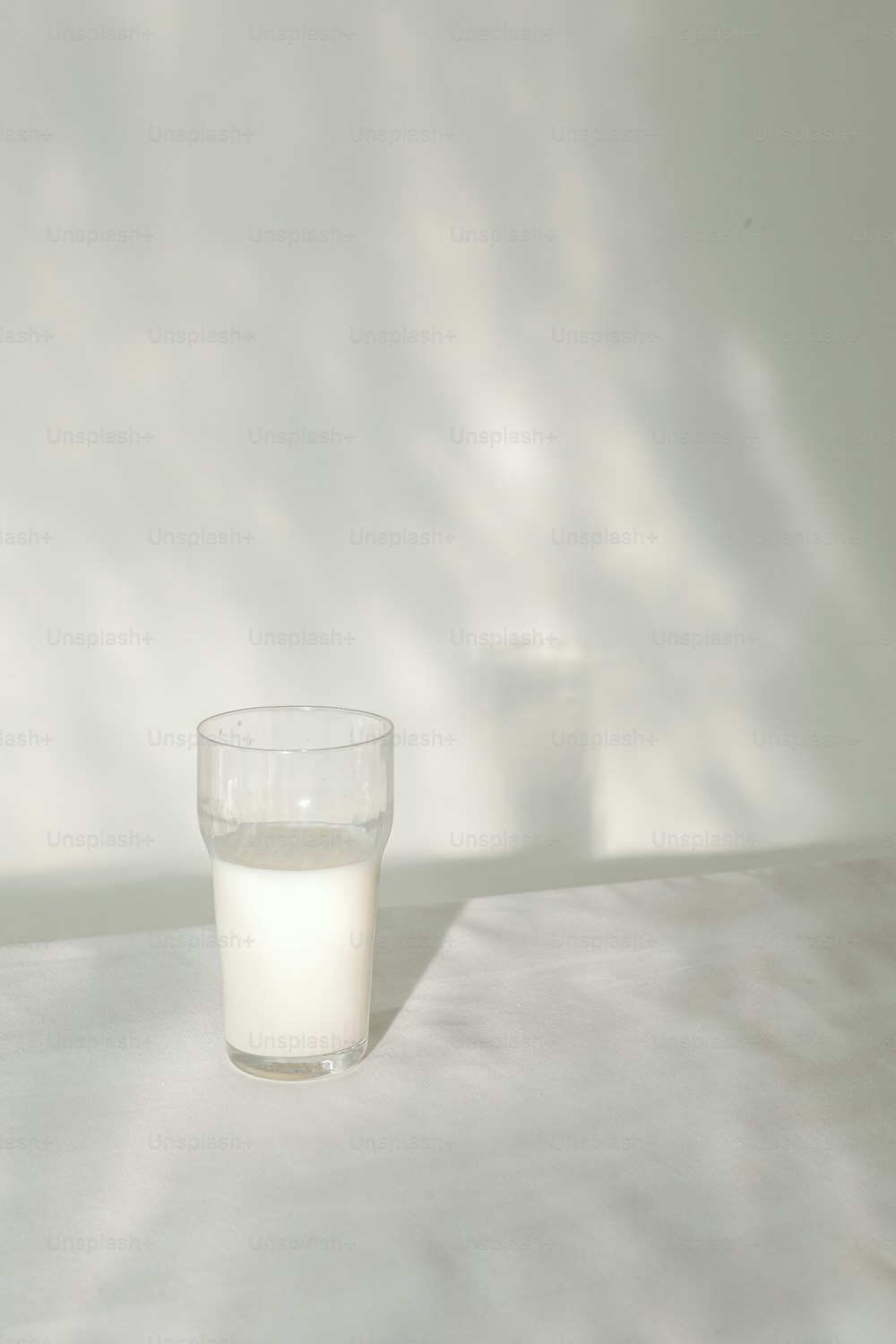 a glass of milk sitting on top of a table