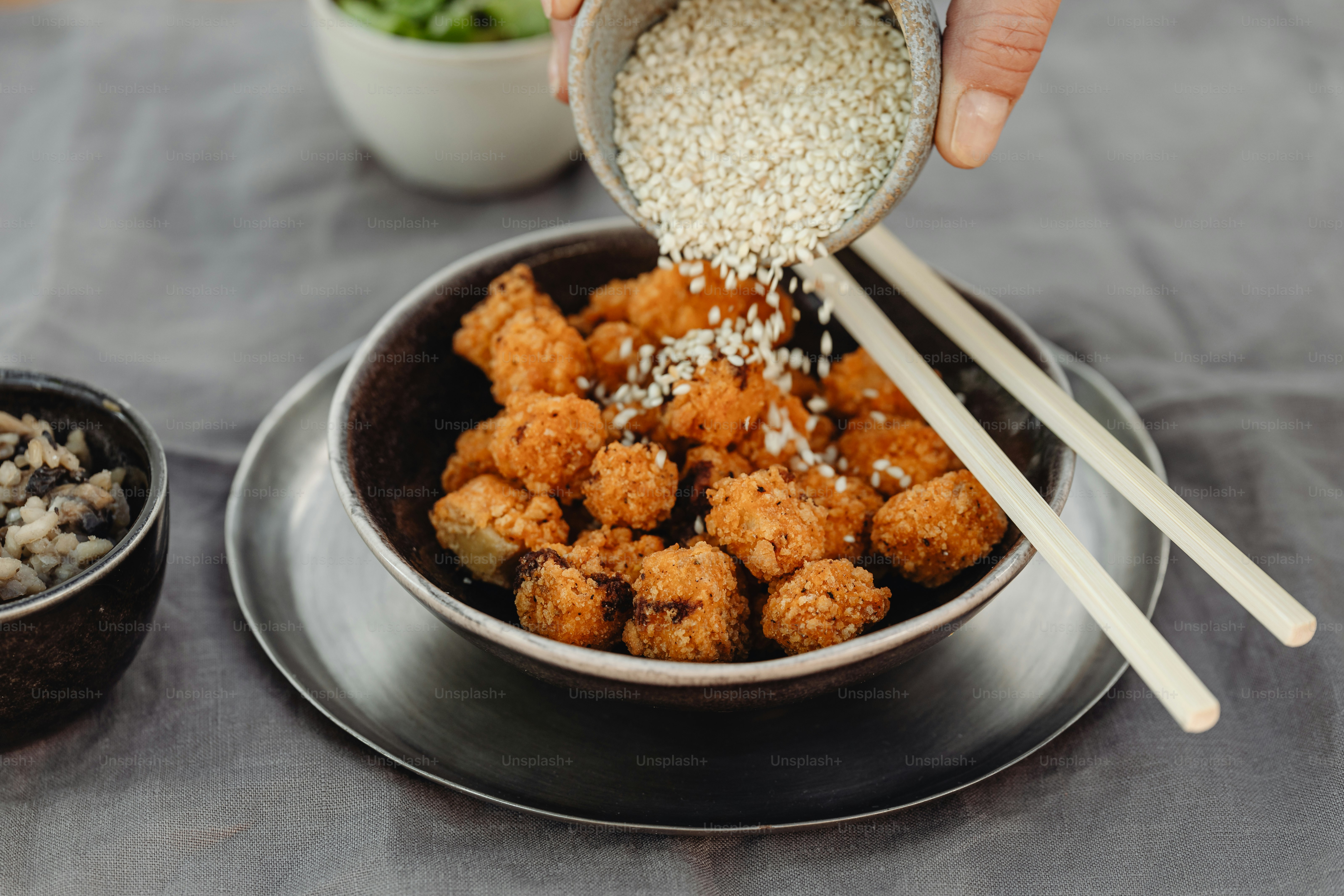 a person pouring rice into a bowl with chopsticks