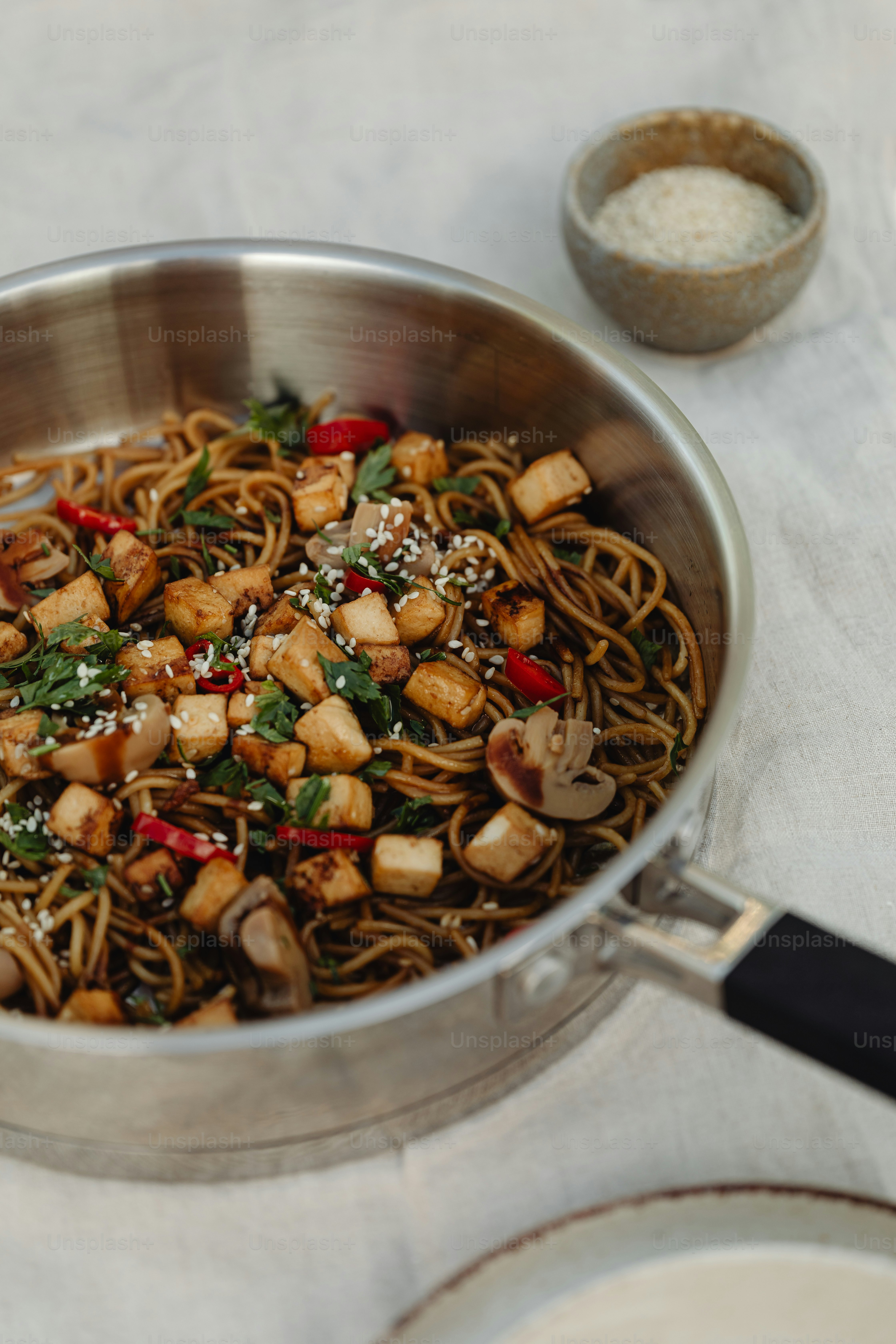 a pan filled with noodles and vegetables on top of a table