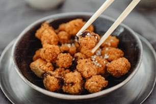 a bowl of food with chopsticks sticking out of it