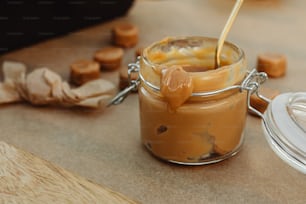 ein Glas Erdnussbutter, aus dem ein Löffel herausragt