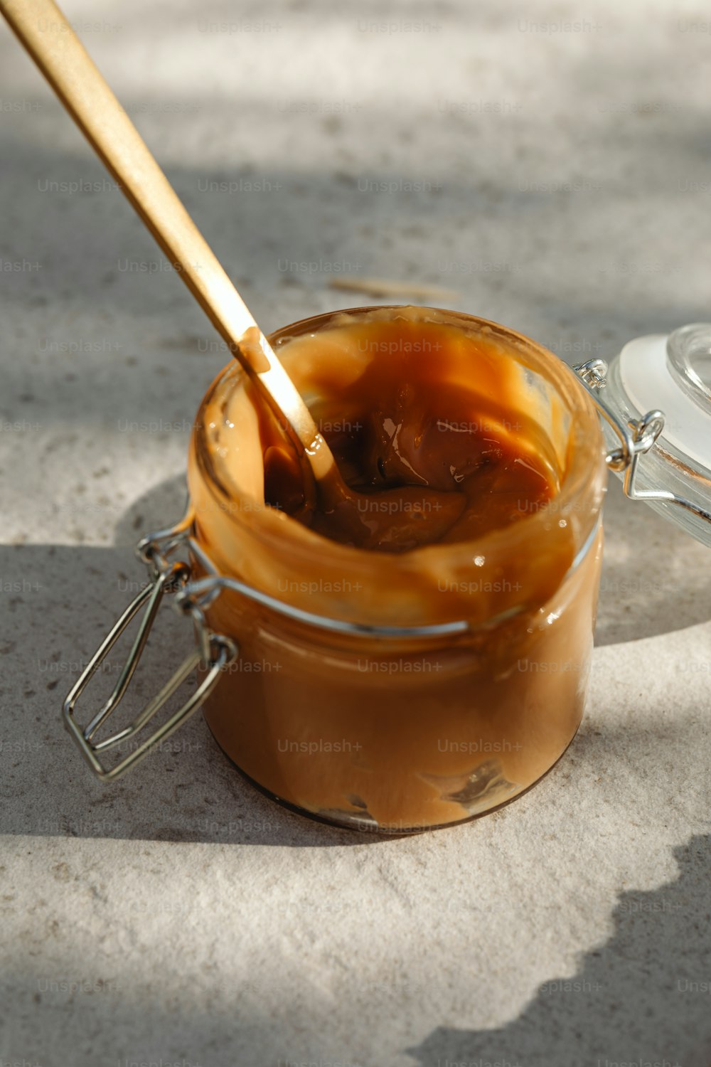 a jar of caramel sauce with a wooden spoon
